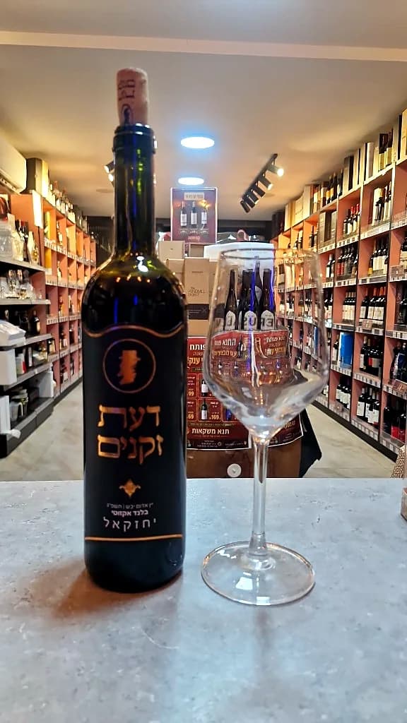 בקבוק יין דעת זקנים וכוס יין על הדלפק